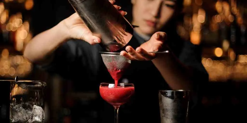 bartender with short nails pouring drink.